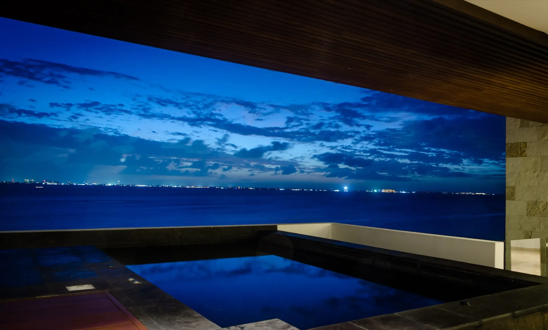 Alberca privada del Penthouse 302 de noche con el skyline de Cancún